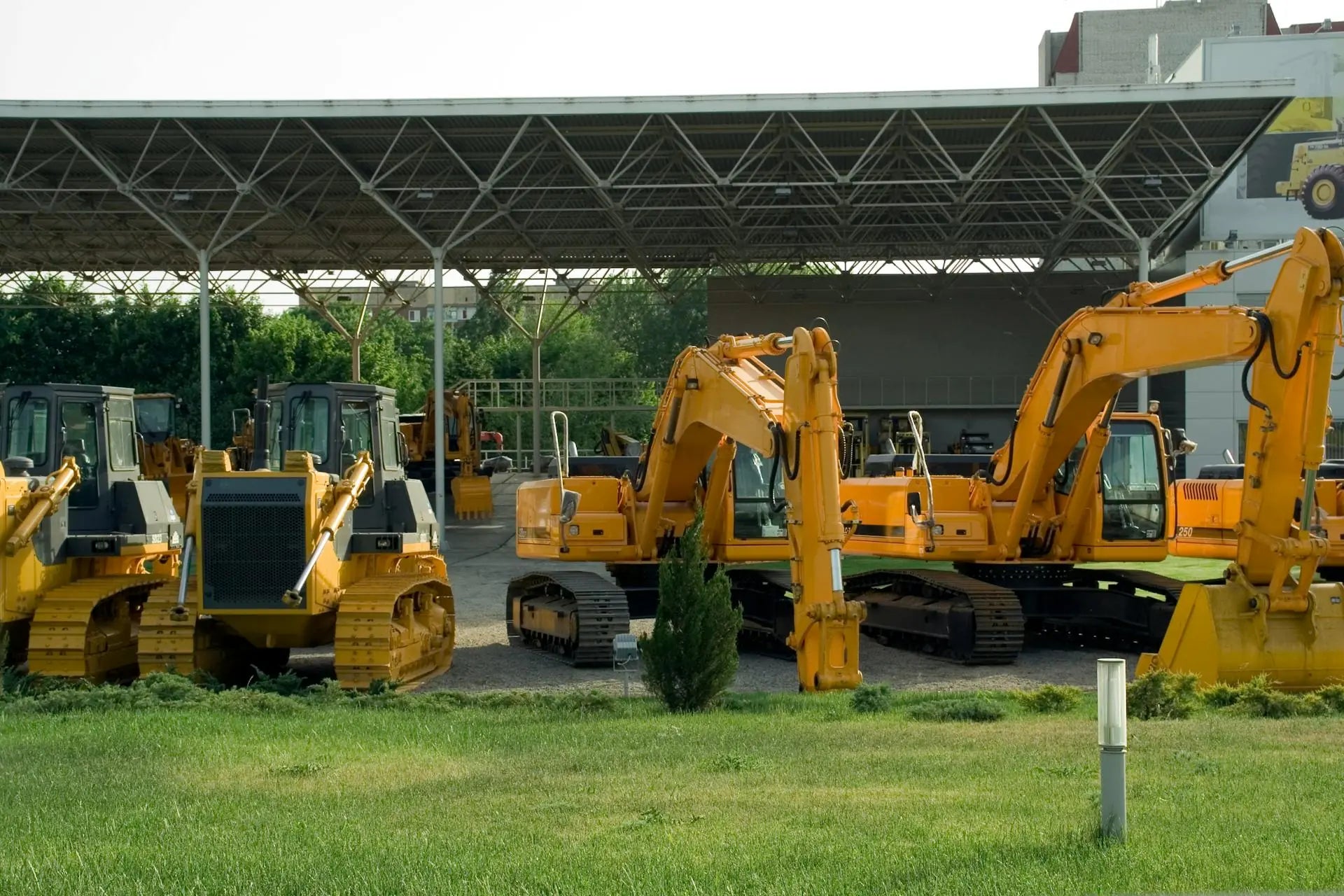 Fleet of construction machinery — excavators and loaders — staged at a jobsite yard.