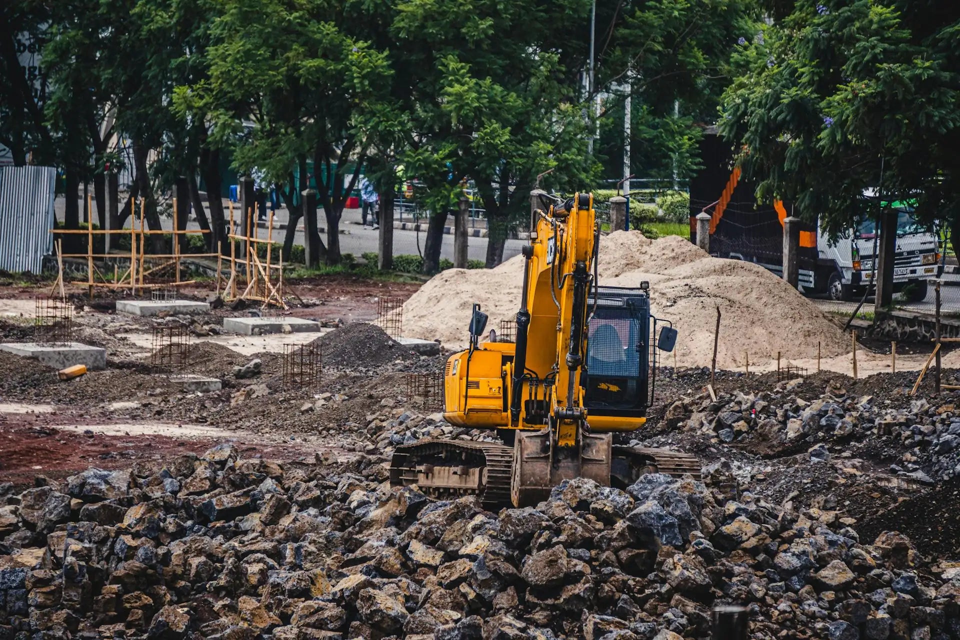 Tracked hydraulic excavator working a demolition site, breaking and moving rubble.