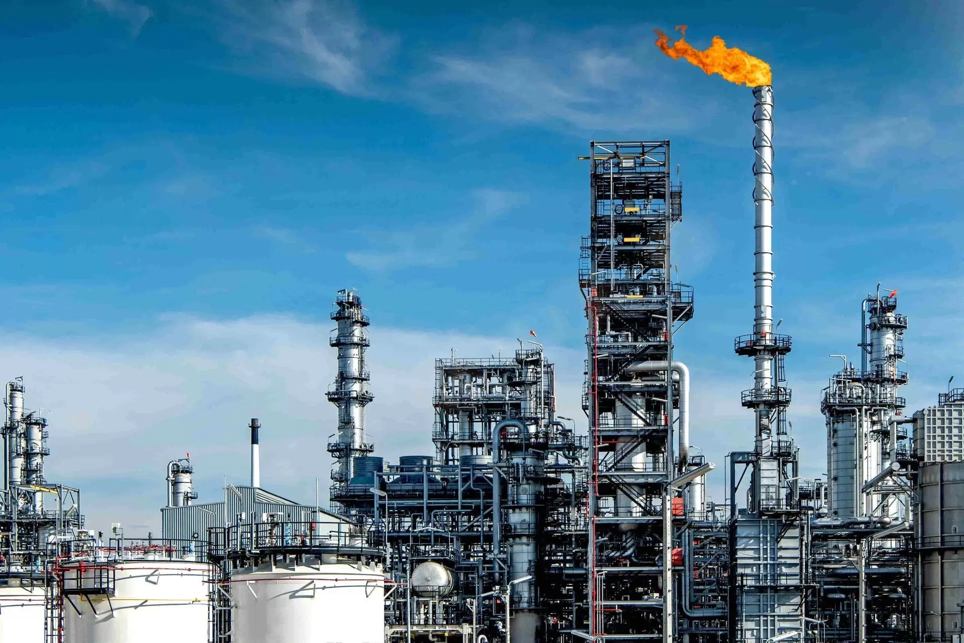 Petrochemical refinery cracking towers and process piping at dusk.